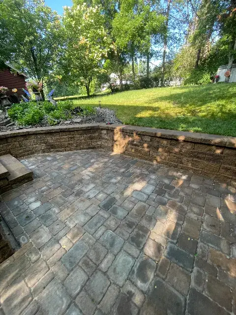 Patio area with paver stones surrounded by landscaping