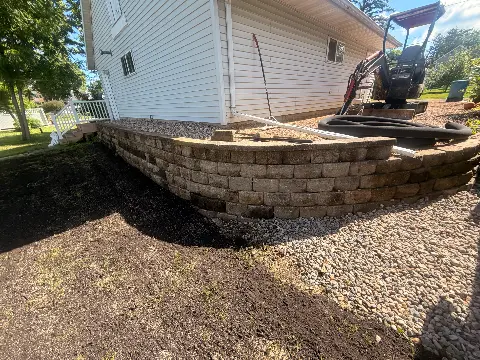 Retaining wall made of stone blocks beside a house in Waconia